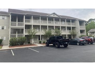 Two-story condo building with ample parking and surrounding trees at 1230 St. George Ln. # B, Myrtle Beach, SC 29588