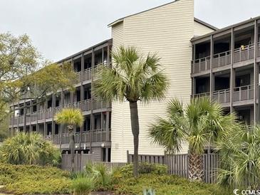 Exterior view of condo building with multiple units, palm trees, and neatly manicured grounds at 212 2Nd Ave. N # 362, North Myrtle Beach, SC 29582