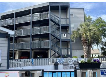 Modern condo building shows stairs leading to upper floors and a glimpse of the community pool at 1500 Cenith Dr. # F103, North Myrtle Beach, SC 29582