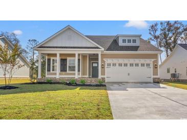 Charming home featuring a well-manicured lawn, two-car garage, and a welcoming front porch at 623 Carter Reid Ct., Longs, SC 29568