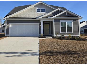 Gray house with white garage door and landscaping at 2104 Ballast Ct., Myrtle Beach, SC 29579