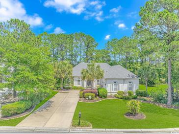 Charming single-story home with mature landscaping, a well-manicured lawn, and a long driveway at 5303 Pheasant Dr., North Myrtle Beach, SC 29582