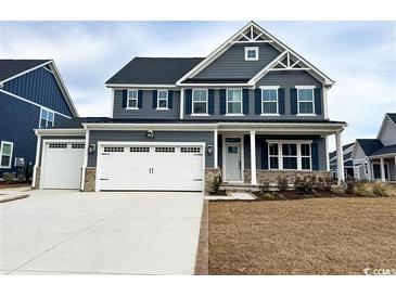 Two-story home with gray siding, white trim, and a three-car garage at 2310 Vera Way, Longs, SC 29568