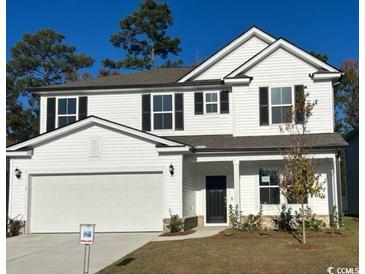 Two-story house with white siding, a two-car garage, and landscaping at 1327 Winding Creek Way, Myrtle Beach, SC 29588