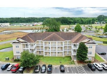 Aerial view of a three-story condo building with parking and landscaping at 110 South Shore Blvd. # 202, Longs, SC 29568