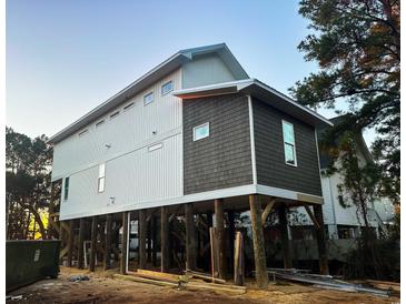 Elevated home with white and dark gray siding, under construction at 189 Brown Pelican Loop, Pawleys Island, SC 29585