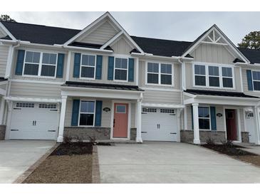 Three-unit townhome building with modern design and attached garages at 2365 Elowen Ln. # 13E, Longs, SC 29568