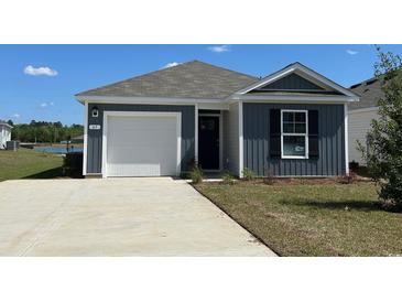 Charming single-story home featuring a gray exterior, white garage door, and well-maintained front lawn at 63 Arbor Crest Ln., Tabor City, NC 28463