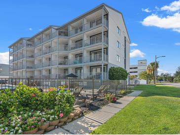 Three-story building with balconies, pool, and landscaping at 2000 S Ocean Blvd. # 203V, Myrtle Beach, SC 29577