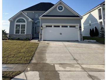 Two-story home showcasing a white garage door, arched windows, and blue-grey facade at 190 Palmetto Harbour Dr., North Myrtle Beach, SC 29582
