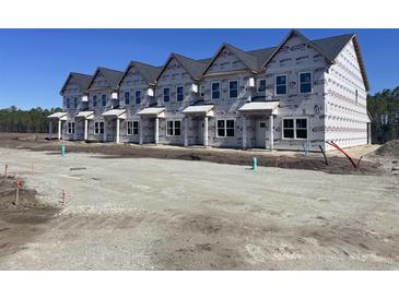 A row of townhomes showcasing a modern architectural design in a developing community at 6876 Watertower Rd. # 104, Longs, SC 29568