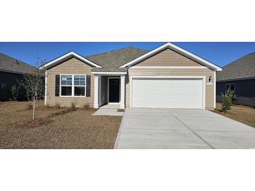 One-story house with beige siding, white garage door, and landscaping at 3865 Lady Bug Dr., Shallotte, NC 28470