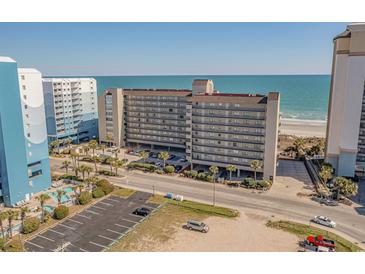 An aerial view of the condo complex, showcasing beautiful ocean views, parking, and lush landscaping at 4719 S Ocean Blvd. # 209, North Myrtle Beach, SC 29582