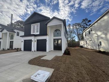 Two-story black and white home featuring a two-car garage, modern design, and appealing architectural details at 2247 Sand Dunes Dr., Myrtle Beach, SC 29577