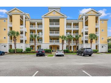 Inviting condo building with multiple balconies, palm trees, manicured landscaping, and ample parking at 601 Hillside Dr. N # 2903, North Myrtle Beach, SC 29582