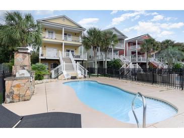 Inviting pool with patio, outdoor fireplace, and three-story townhouses at 1335 Hidden Harbor Rd., Myrtle Beach, SC 29577