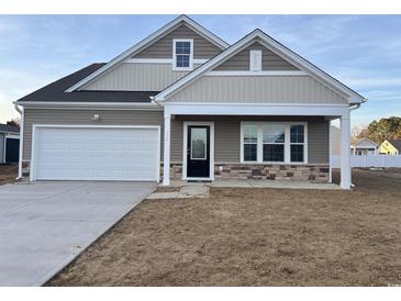 Two-story house with beige and brown siding, white garage door, and landscaping at 714 Night Lotus Dr., Calabash, NC 28467