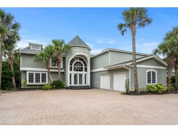 Grand two-story home with a large driveway and lush landscaping at 8000 Beach Dr., Myrtle Beach, SC 29572