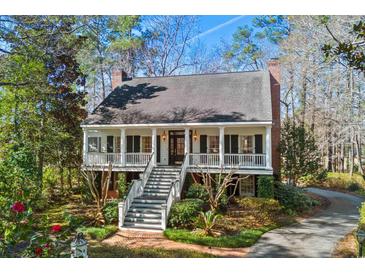 Charming two-story home featuring a large front porch, brick chimneys, and professionally landscaped yard at 4569 Carriage Run Circle, Murrells Inlet, SC 29576