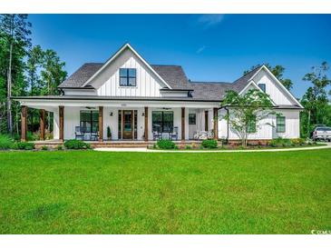 White farmhouse exterior with large front porch and lush green lawn at 1055 Academy Dr., Conway, SC 29526