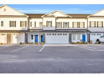 New townhomes with white siding, black shutters, blue doors, and two-car garages in a community with ample parking at Lot 41 Lineback Pl. # 41, Longs, SC 29568