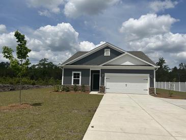 Charming single-story home featuring a two-car garage, attractive gray siding, and well-manicured lawn at 4723 Huckleberry Ln., Conway, SC 29526