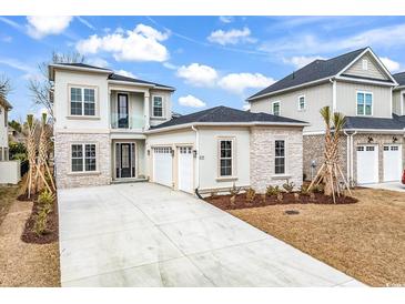 A modern home featuring stone accents, a three-car garage, and a private balcony at 835 Waterton Ave., Myrtle Beach, SC 29579