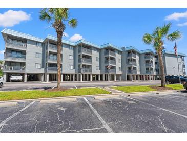 Low-rise condos with ample parking and palm trees under a clear blue sky at 6000 N Ocean Blvd. # 330, North Myrtle Beach, SC 29582