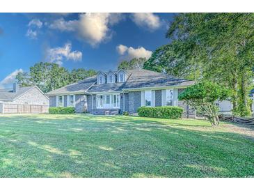 Brick house with a spacious lawn and mature trees at 1437 Shoreline Dr., Myrtle Beach, SC 29577
