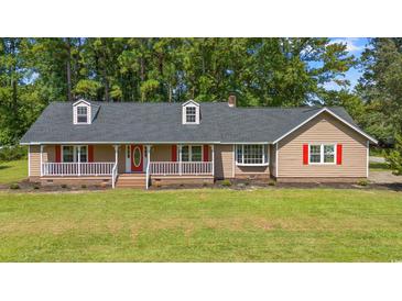 Charming home featuring a welcoming front porch and red accents at 4935 Meadow St., Loris, SC 29569