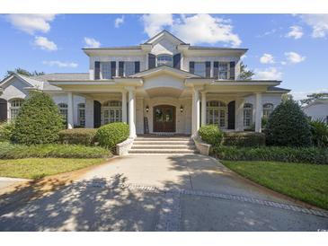 Stunning two-story white brick home with large columns and professionally landscaped front yard at 9318 Cove Dr., Myrtle Beach, SC 29572