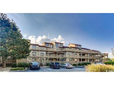 Exterior shot of multi-story condo building with ample parking and stairs to the units on upper floors at 501 Maison Dr. # B10, Myrtle Beach, SC 29572