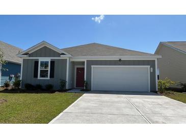 Charming single-story home with gray siding, a red front door, and a spacious two-car garage at 559 Duvall St., Longs, SC 29568