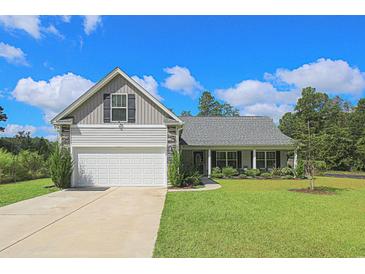 Charming one-story home with a well-maintained lawn and attached two-car garage with beautiful blue skies at 2000 Easy St., Conway, SC 29526
