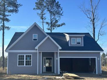 Charming gray home featuring a two-car garage and a welcoming front porch at 116 Infinity Ln., Loris, SC 29569