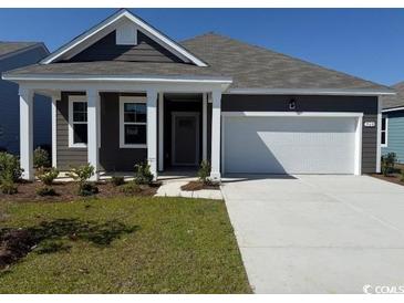 Charming single-story home featuring manicured lawn and a spacious two-car garage at 560 Duvall St., Longs, SC 29568