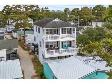 Charming two-story beach home features balconies, white railings, and glimpses of the surrounding neighborhood at 6001 - N14 S Kings Hwy., Myrtle Beach, SC 29575