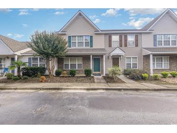 Tan two-story townhome with green door and landscaping at 984 Pembroke Ct. # 984, Myrtle Beach, SC 29577