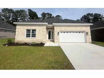 Charming single-story home boasts a brick facade, well-manicured lawn, and an attached two-car garage at 293 Waterfall Circle, Little River, SC 29566