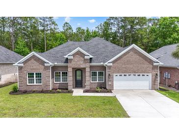 Charming brick home featuring a well-manicured lawn, two-car garage and a stylish, arched front door at 297 Waterfall Circle, Little River, SC 29566
