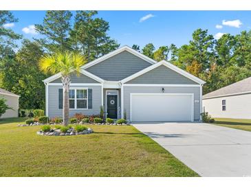 Charming single-Gathering home with gray siding, a well-maintained lawn, and a two-car garage at 149 Harmony Ln., Myrtle Beach, SC 29588