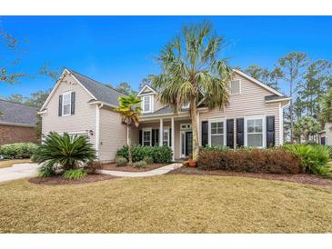 Charming home showcasing a landscaped yard with mature palm trees and a welcoming front porch at 621 Elgin Ct., Myrtle Beach, SC 29579