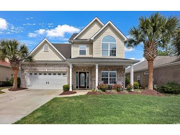 Charming two-story home featuring brick accents, a well-manicured lawn, and a welcoming front porch at 1002 Summers Pl., North Myrtle Beach, SC 29582