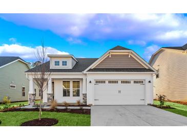 Charming single-Gathering home with a two-car garage, landscaped lawn, and classic white siding at 5028 Cambria Ct., Little River, SC 29566