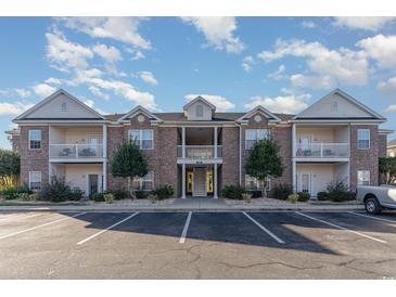 Attractive two-story condo building with brick facade and private balconies under a partly cloudy sky at 2073 Silver Crest Dr. # 4 D, Myrtle Beach, SC 29579