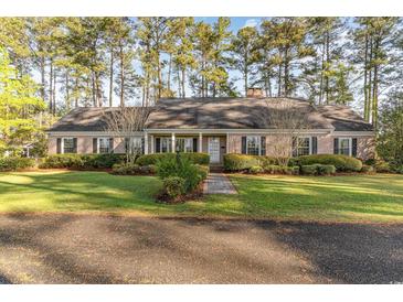Charming brick ranch home with lush landscaping and a welcoming front porch at 2807 Graham Rd., Conway, SC 29526