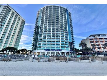 View of condo building from the beach featuring blue glass balconies and ocean views at 107 S Ocean Blvd. # 808, Myrtle Beach, SC 29577
