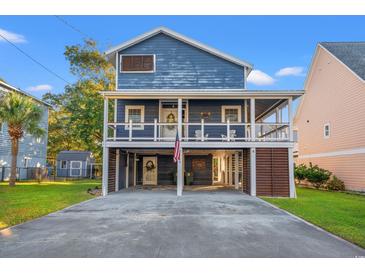 Two-story home with blue siding, a wrap-around porch, and a spacious driveway at 508 21St Ave. N, North Myrtle Beach, SC 29582