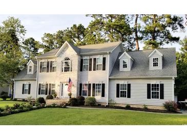 Beautiful two-story home with white siding, black shutters, manicured lawn and an American flag at 121 Grand Palm Ct., Myrtle Beach, SC 29579
