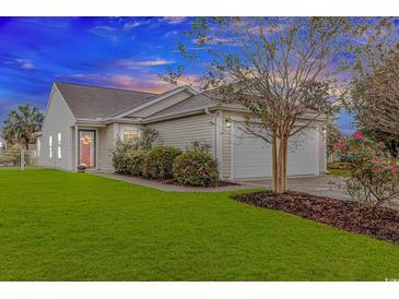Charming single-story home featuring a two-car garage, well-manicured lawn, and beautiful landscaping at 133 Junco Circle, Longs, SC 29568